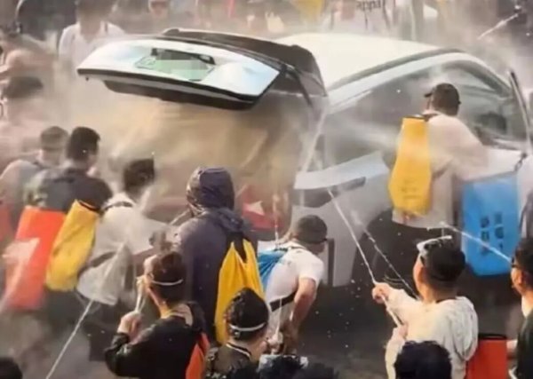泼水节现场一汽车被多人拉开喷水，车内冒烟，已报警；当地回应